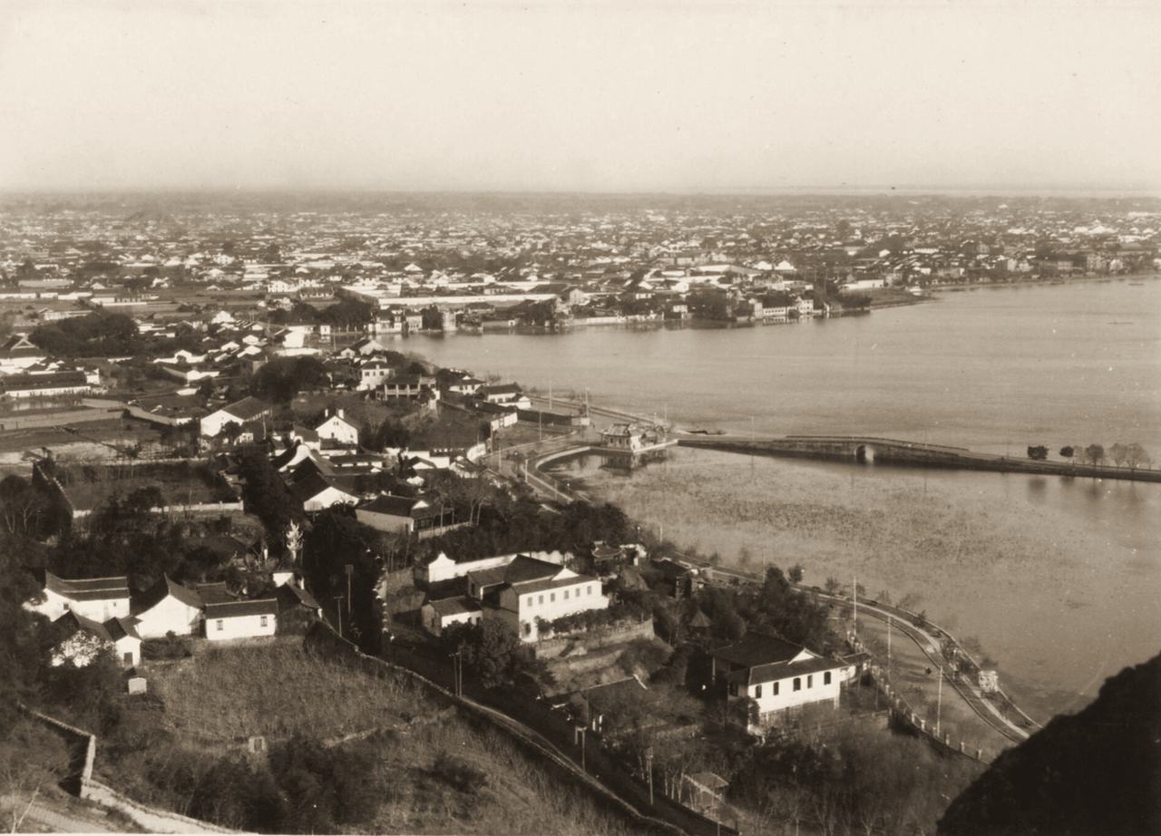Hangzhou in 1931 from a hillside: tiled roofs and Western-style houses in the foreground, the causeway and Broken Bridge on the lake, and the city stretching away.