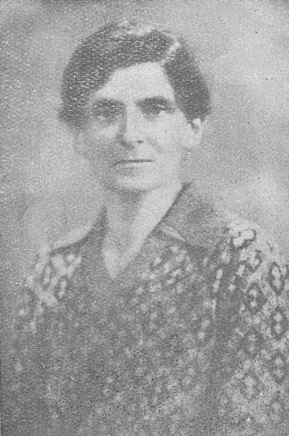 Head-and-shoulders portrait of Margaret Woods in her forties: short dark wavy hair, a steady look, a patterned cardigan.