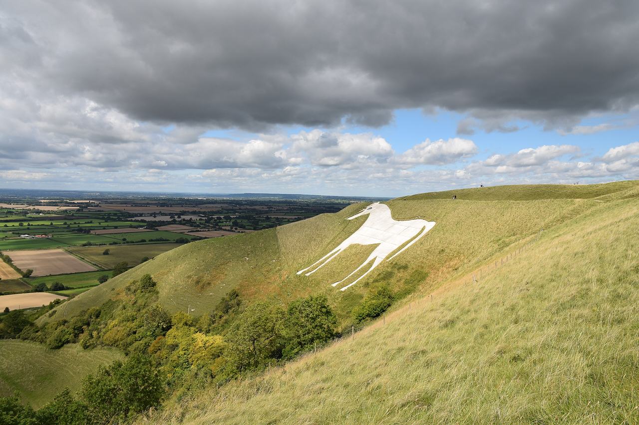 The white horse cut into the green chalk hillside above Westbury, under a heavy grey sky.